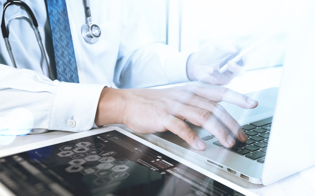 Doctor using laptop and tablet for HIPAA compliant healthcare IT