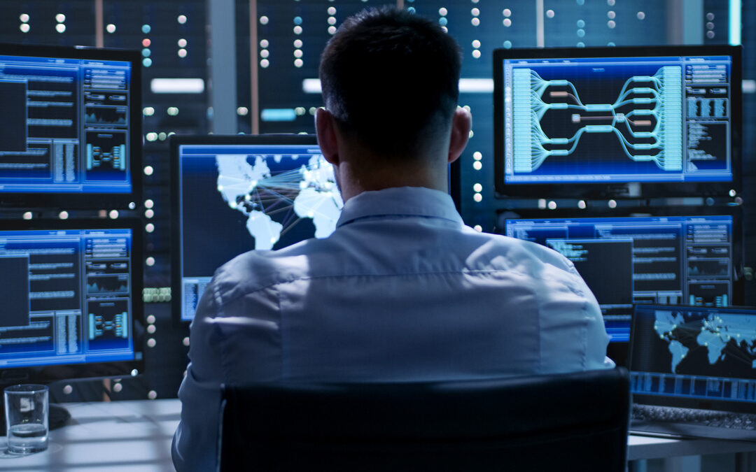 CTO overseeing network security on multiple monitors