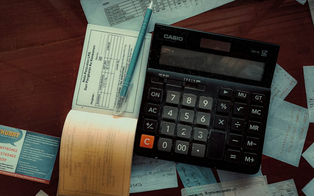 A calculator and paperwork on an accountant's desk, representing IT compliance and data security for accounting firms