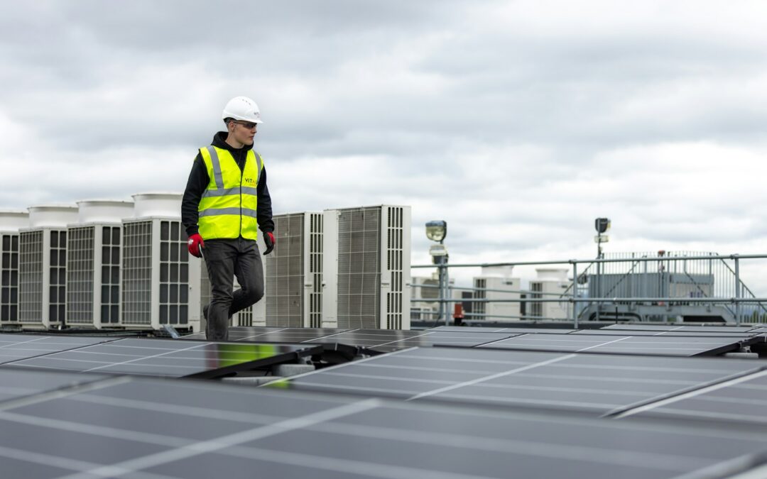 A field-service technician working on a rooftop, representing HVAC and field crews who rely on mobile devices